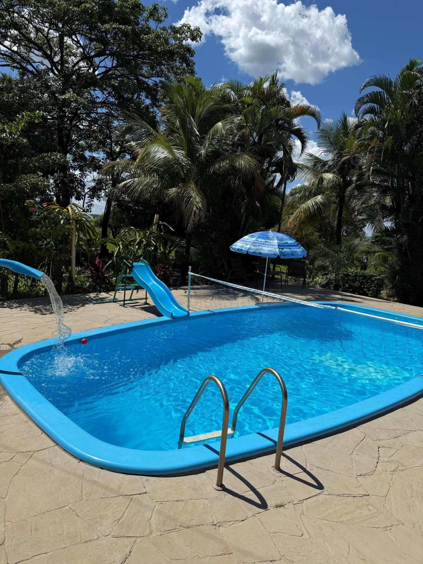 Piscina aquecida do Recanto Boa Fé cercada por palmeiras