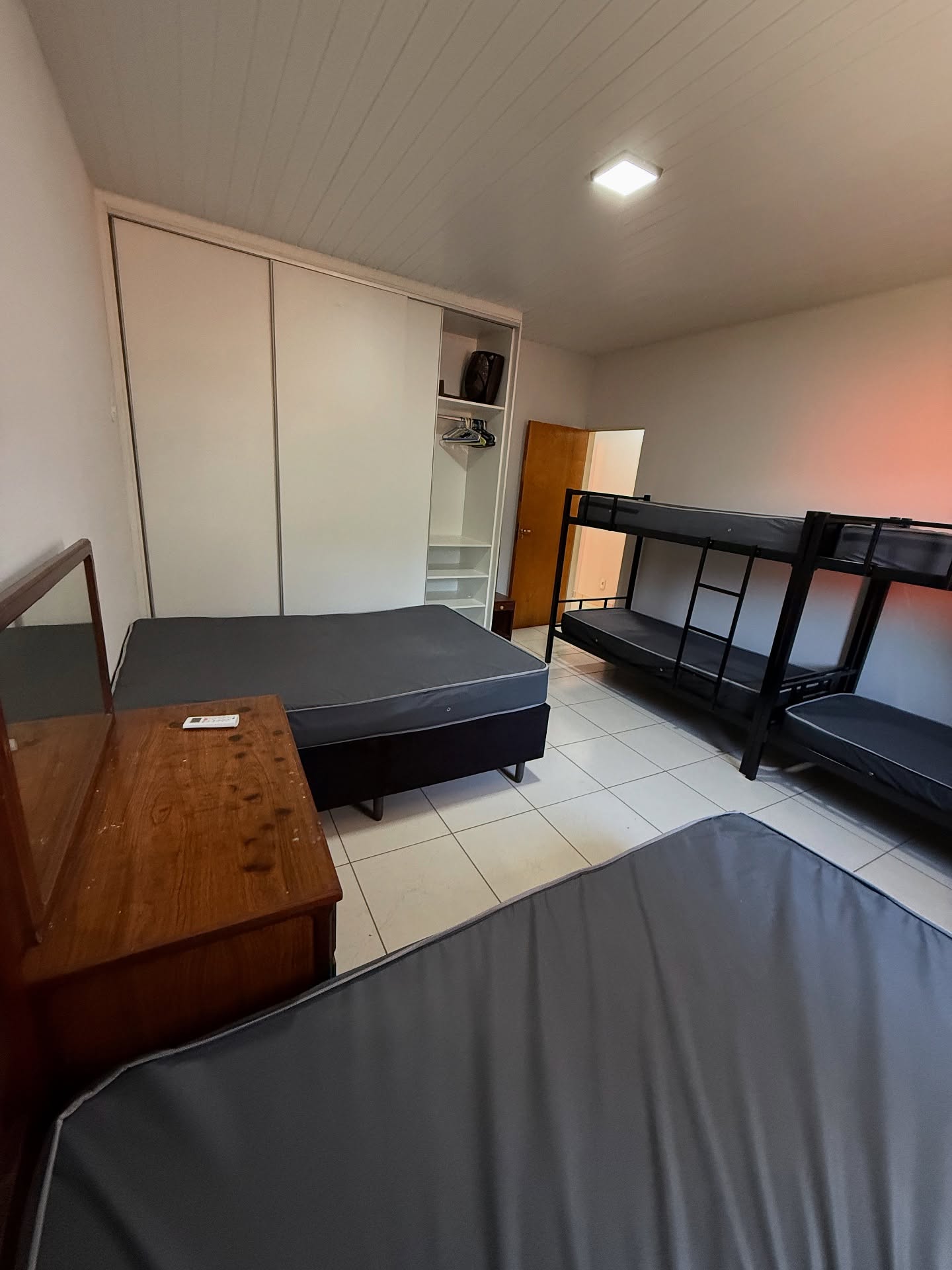 Quarto com cama de casal, beliche e ar-condicionado
