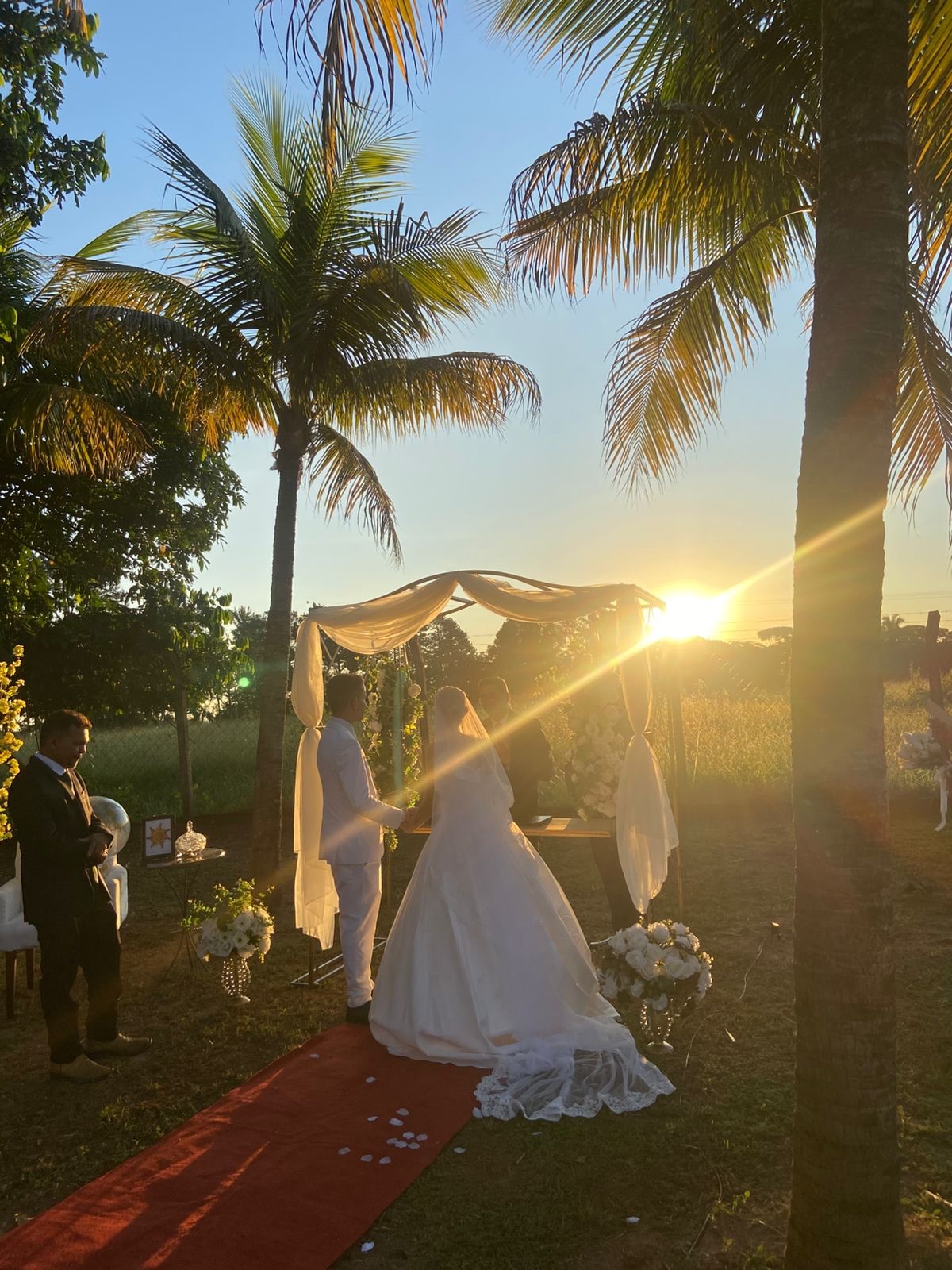 Cerimônia de casamento ao pôr do sol entre palmeiras