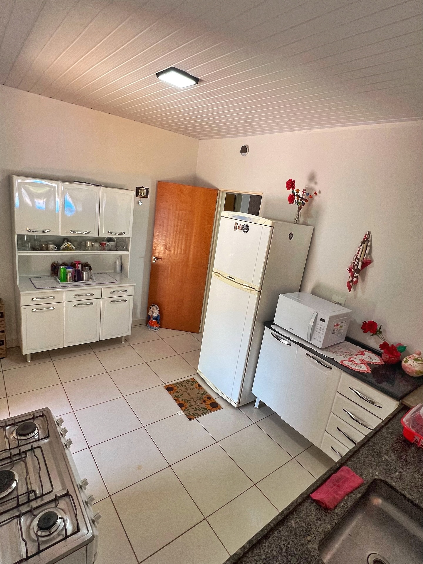 Cozinha equipada com fogão, geladeira e micro-ondas